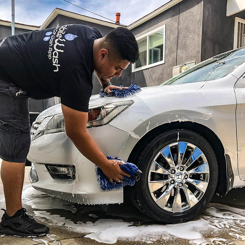 MobileWash washer gives a hand wash to the front of a silver Honda Accord for a car cleaning.